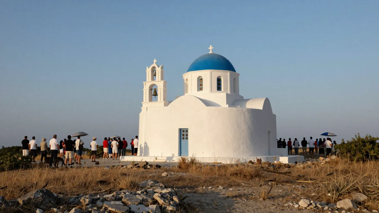 Ασπρισμένο εκκλησάκι με γαλάζιο τρούλο σε λόφο, περιτριγυρισμένο από πλήθος που φαίνεται από πίσω κάτω από τον ήλιο του απογεύματος.
