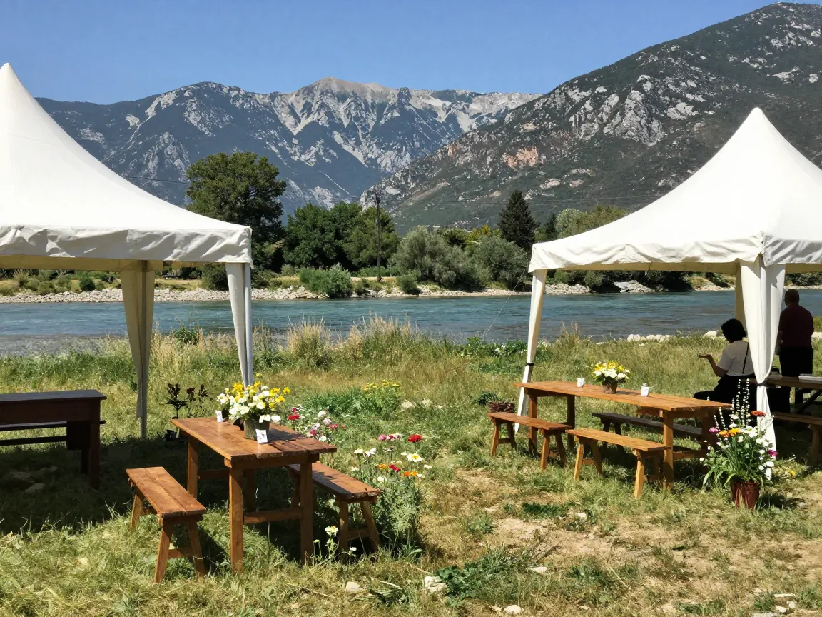 Riverside baptism reception under white marquee tents with wooden tables and Taygetos mountains in the distance.