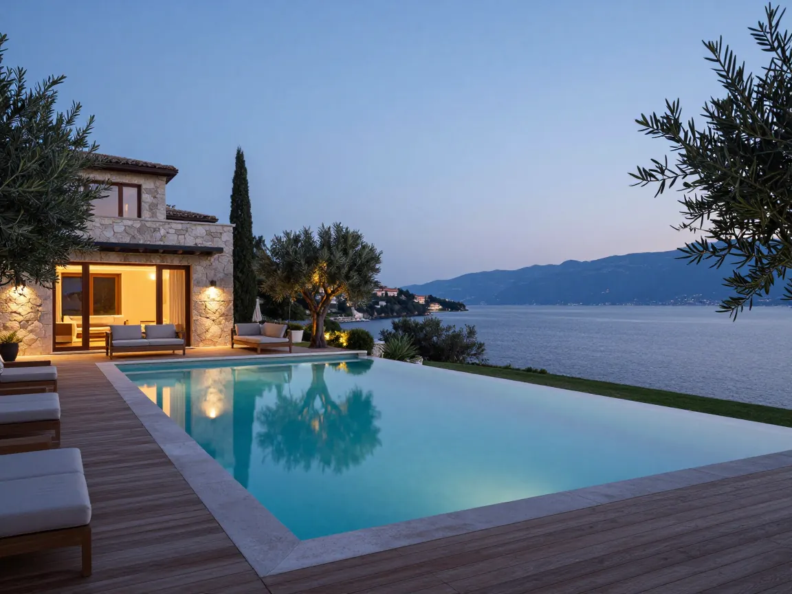 Infinity pool of a stone villa overlooking Keri Lake and the sea at dusk in Zakynthos.